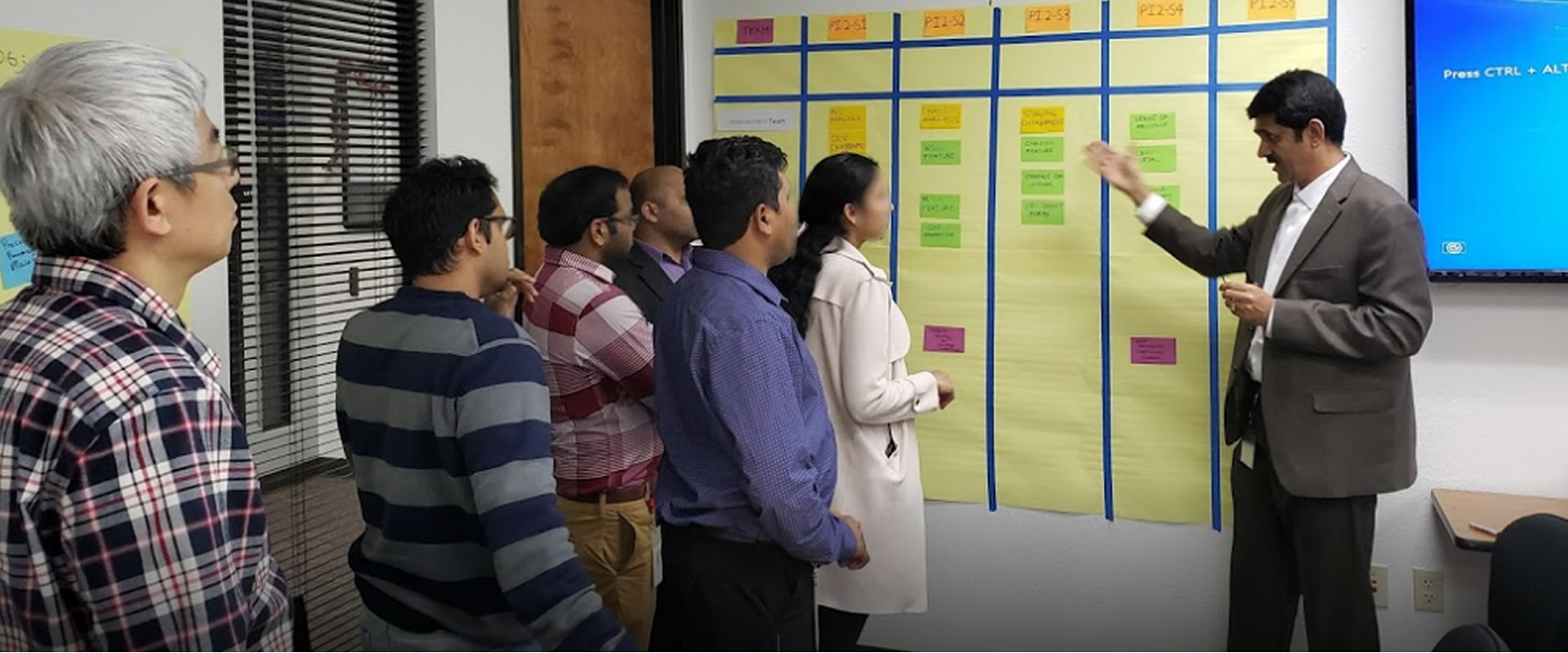 Workshop participants discussing a planning board with their facilitator
